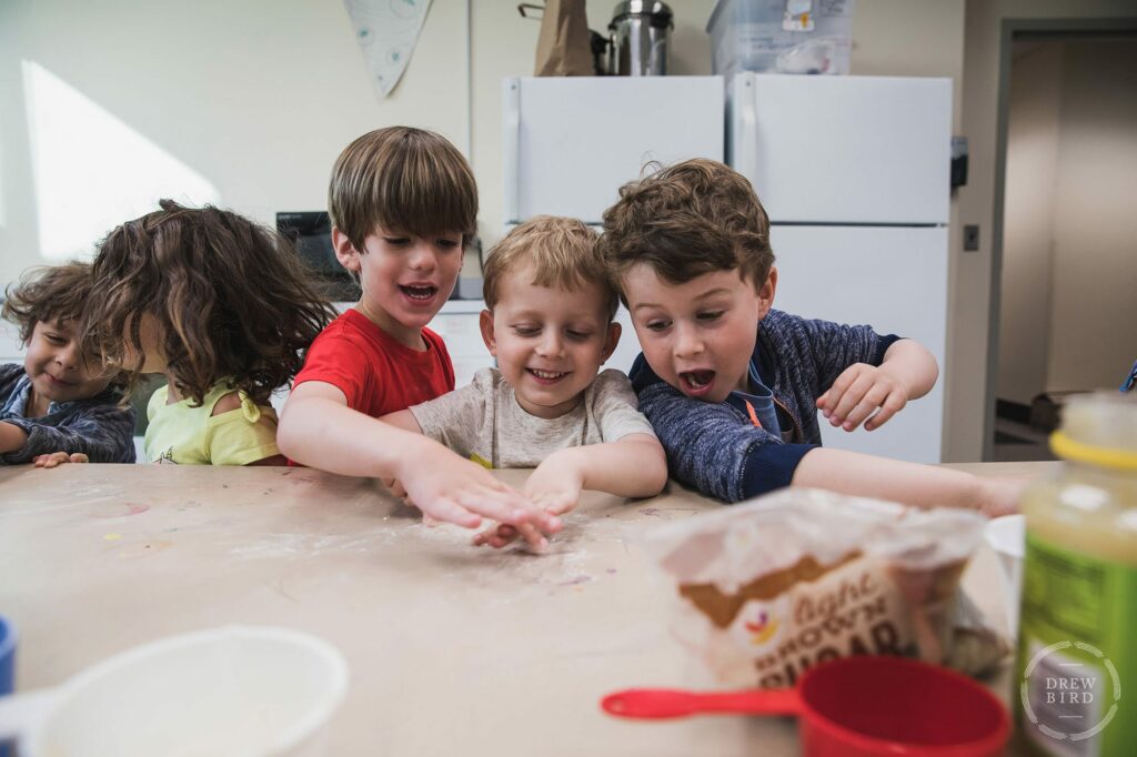 Three young boys laughing and preparing food in a kitchen classroom at Poughkeepsie Day School. San Francisco education marketing photographer Drew Bird. San Jose school branding photographer.