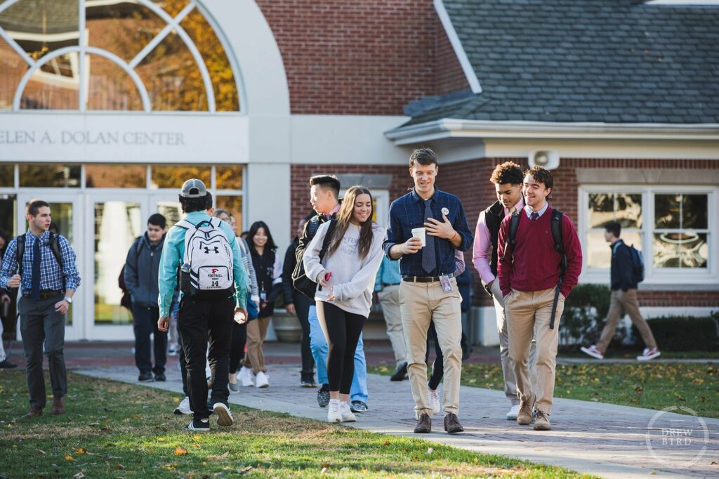 A teacher talks with students while walking on campus at Friends Academy in New York. San Francisco education marketing photographer Drew Bird. San Jose school branding photographer.