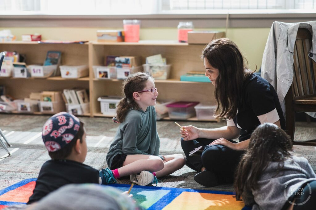 A teacher works with a young student in the classroom at solomon schechter day school in Boston. San Francisco education marketing photographer Drew Bird. San Jose school branding photographer.